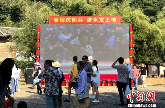户外LED屏幕播放国庆大阅兵、爱国主义电影。供图